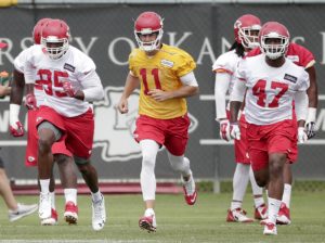 Kansas City Chiefs quarterback Alex Smith (11) and  linebackers Sage Harold (47) and Josh Martin (95) participate in a drill during an NFL football organized team activity Thursday, June 11, 2015, in Kansas City, Mo. (AP Photo/Charlie Riedel)