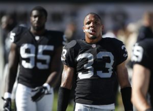 Oakland Raiders strong safety Tyvon Branch (33) and defensive end Benson Mayowa (95) stand on the sideline late in the fourth quarter of an NFL football game against the Houston Texans, Sunday, Sept. 14, 2014, in Oakland, Calif. Houston won the game 30-14. (AP Photo/Beck Diefenbach)