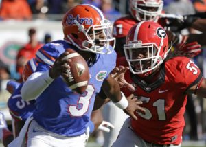 Florida quarterback Treon Harris (3) looks for a receiver as he is pressured by Georgia linebacker Ramik Wilson (51) during the first half of an NCAA college football game in Jacksonville, Fla., Saturday, Nov. 1, 2014. (AP Photo/John Raoux)