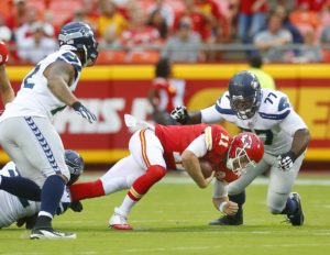 Aug. 21, 2015; Kansas City, MO; Chiefs quarterback Alex Smith goes in the grasp of Seahawks defensive end Brandon Mebane as defensive end Ahtyba Rubin (77) closes in. (Chris Neal/The Topeka Capital-Journal)